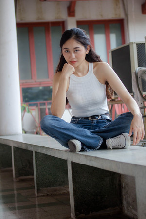 Portrait of thai china adult beautiful girl White shirt blue jeans relax and smile