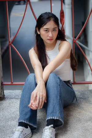 Portrait of thai china adult beautiful girl White shirt blue jeans relax and smileの写真素材