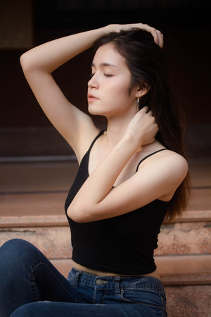 Portrait of thai china adult beautiful girl black shirt blue jeans relax and smileの写真素材