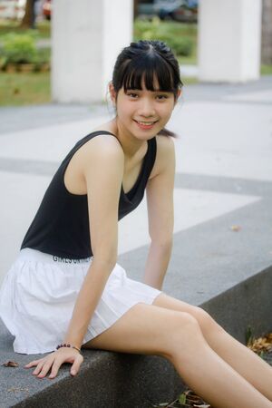 Portrait of thai adult beautiful girl black shirt white skirt relax timeの写真素材