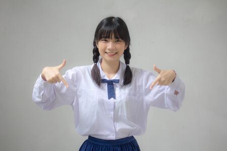 Portrait of thai high school student uniform beautiful girl pointingの写真素材