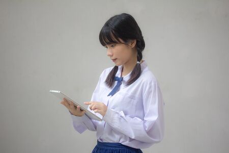 thai high school student uniform beautiful girl using her tabletの写真素材