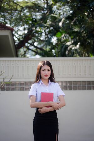 thai adult student university uniform beautiful girl relax and smileの写真素材