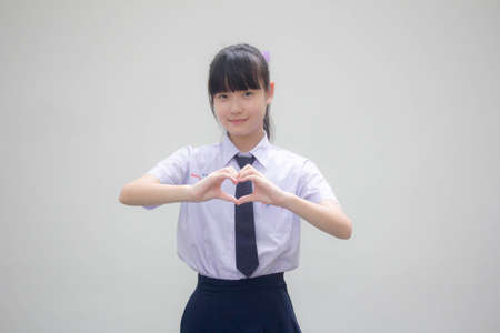 Portrait of thai high school student uniform beautiful girl give heart
