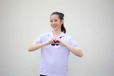 Portrait of thai Junior high school student uniform beautiful girl give heart