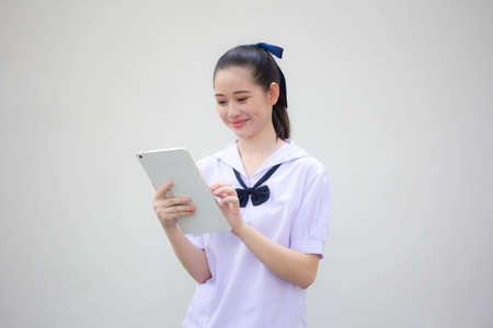 asia thai Junior high school student uniform beautiful girl using her tabletの写真素材