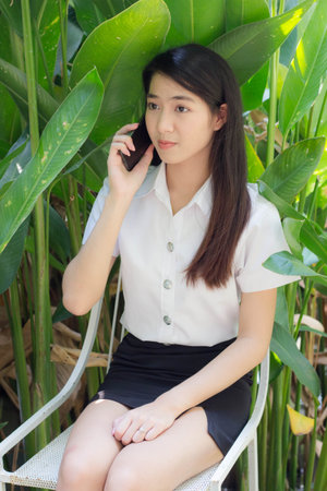 thai adult student university uniform beautiful girl calling smartphoneの写真素材