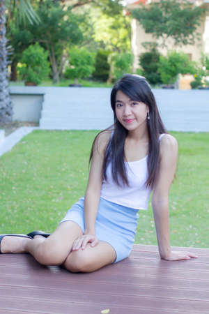 Portrait of thai adult beautiful girl white shirt light blue skirt relax time