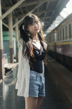 Portrait of thai japan adult beautiful girl white shirt blue jeans relax time, train station fashion
