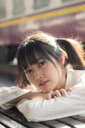 Portrait of thai japan adult beautiful girl white shirt blue jeans relax time, train station fashionの写真素材