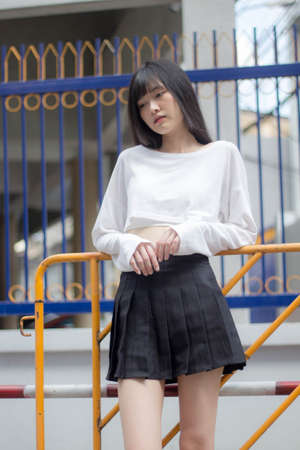 Portrait of thai adult beautiful girl white shirt black skirt relax timeの写真素材