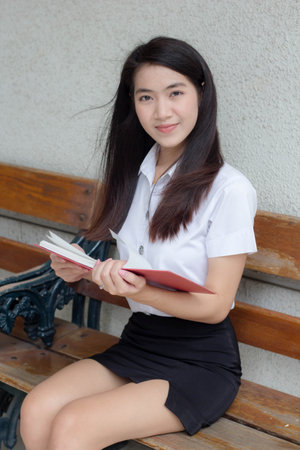 thai adult student university uniform beautiful girl read a bookの写真素材