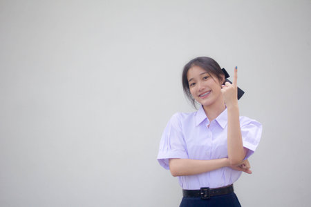 Portrait of thai high school student uniform beautiful girl pointingの写真素材