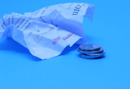 Wrinkled invoice and coins, blue toned (without logos)の写真素材
