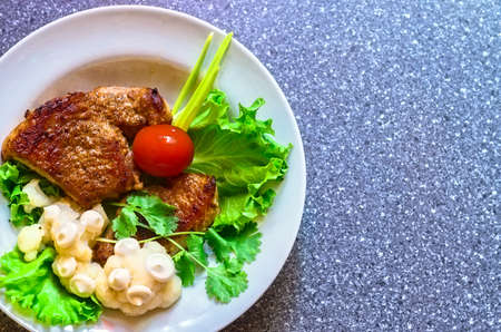 juicy grilled pork chop with greensの写真素材