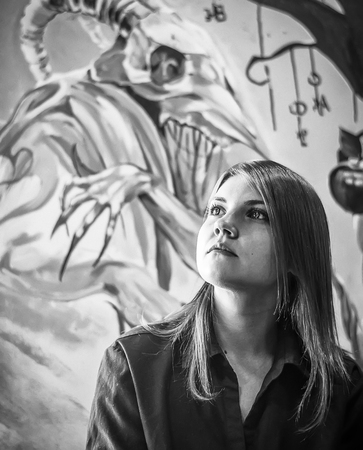 Portrait of beautiful young girl on the background of a painted monster. Black and whiteのeditorial素材