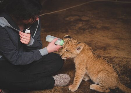 Photo where a tigrenek man gives milk from a bottleの写真素材