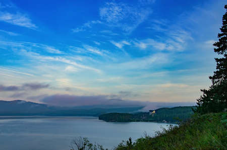 dawn over the lake in the old mountains of the southern Ural. Lake among the wooded hills, colored...