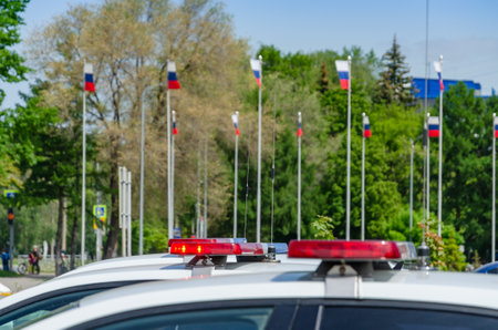 Police car flashing light. In the background, the flags of Russia are out of focus.の写真素材