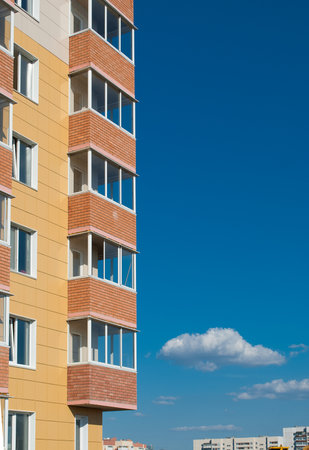 Fragment of a high-rise building with balconies, vertical photo. Real estate backgroundの写真素材