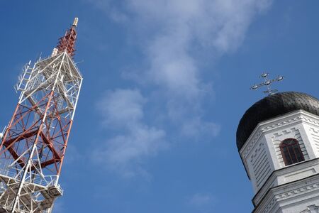 Television tower and dome of the church against the blue sky