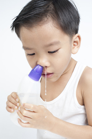 Sometime my children has not a smooth breath and they practice to use saline solution to clean their nasal by themselvesの写真素材