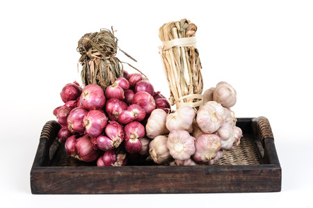 Thai red onion and garlic on bamboo mat on white backgroundの写真素材