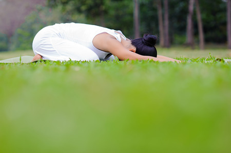 Beautiful woman practicing yoga in the park.Child's Pose / Balasana.の写真素材