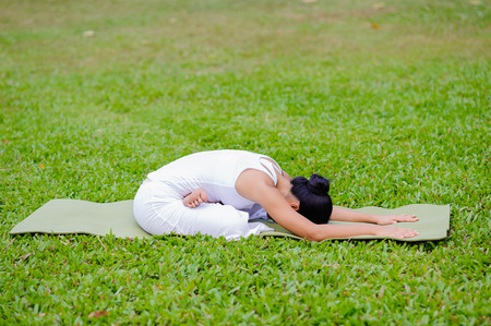 Beautiful woman practicing yoga in the park.Lotus (Variation) Pose / Padmasana.の写真素材