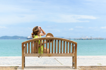 Woman relax on the bench at the Thai beach in a sunny dayの写真素材