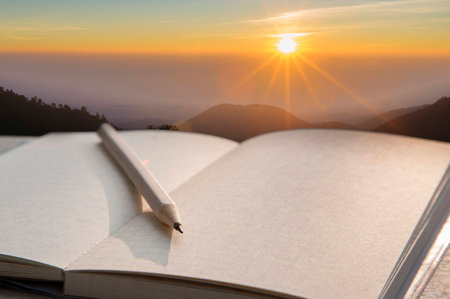 Note book and pencil during sunrise background.の写真素材