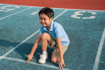 Two boys run competition on the green trackの写真素材