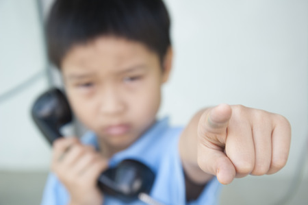 Focus hand of  Boy using the old public phone boothの写真素材