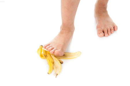 Child food step on banana shell on white backgroundの写真素材