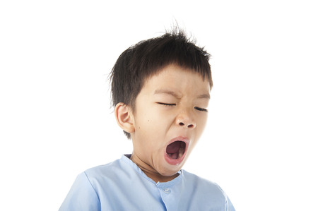 Boy yawn after woke up in the morning isolated on white backgroundの写真素材