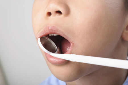The boy has checking toot and mouth by dental mirror