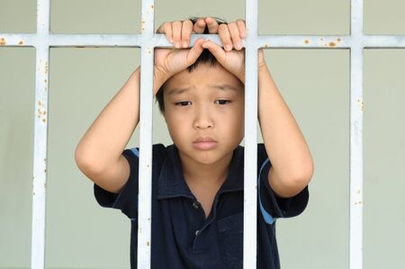 young kid at the back of the iron barの写真素材