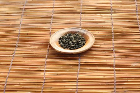 Dry herb tea on wood plate and grass mat
