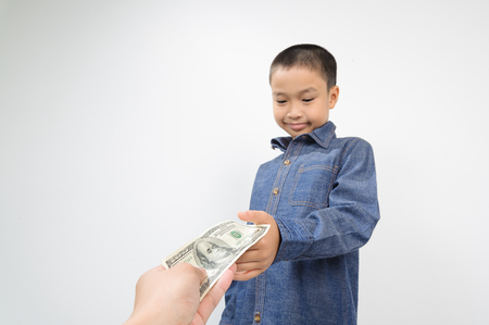 Out focus face of Young boy receive american bank note from hand of manの写真素材
