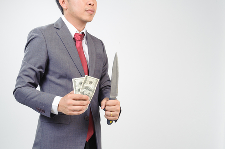 Man in grey suit holding knife and dollar noteの写真素材