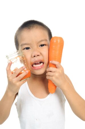 Young boy happy to drink carrot juice on white backgroundの写真素材