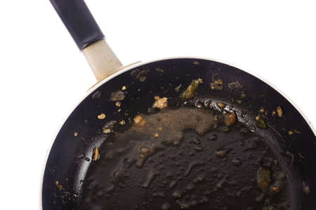 Dirty used iron pan after cook on white backgroundの写真素材