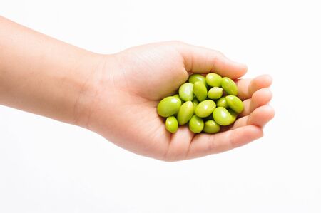 Boil soy bean in boy hand on white backgroundの写真素材