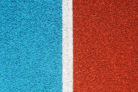Running track made from red and blue granule rubber split by white lineの写真素材