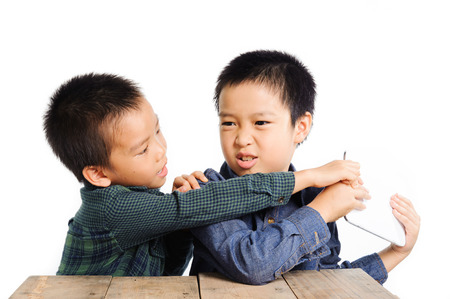 Two boy grab and competition to get tablet device on white backgroundの写真素材