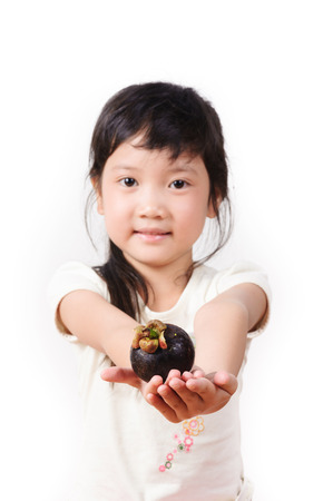 Thin focus on hand of Young asian girl hold mangosteen on white backgroundの写真素材