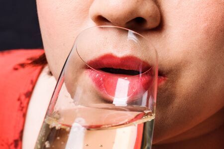 Close up red lip Asian young woman drinking champagneの写真素材