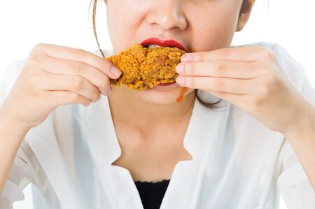 Close up Beautiful young thai woman in white shirt crispy fried chicken on white backgroundの写真素材