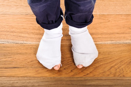 White old sock damage and hole in kind feetの写真素材