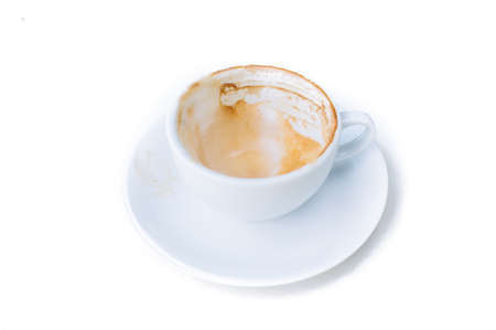 Thin focus on Milk foam remainning in white cup after finish cappuccino on white tableの写真素材